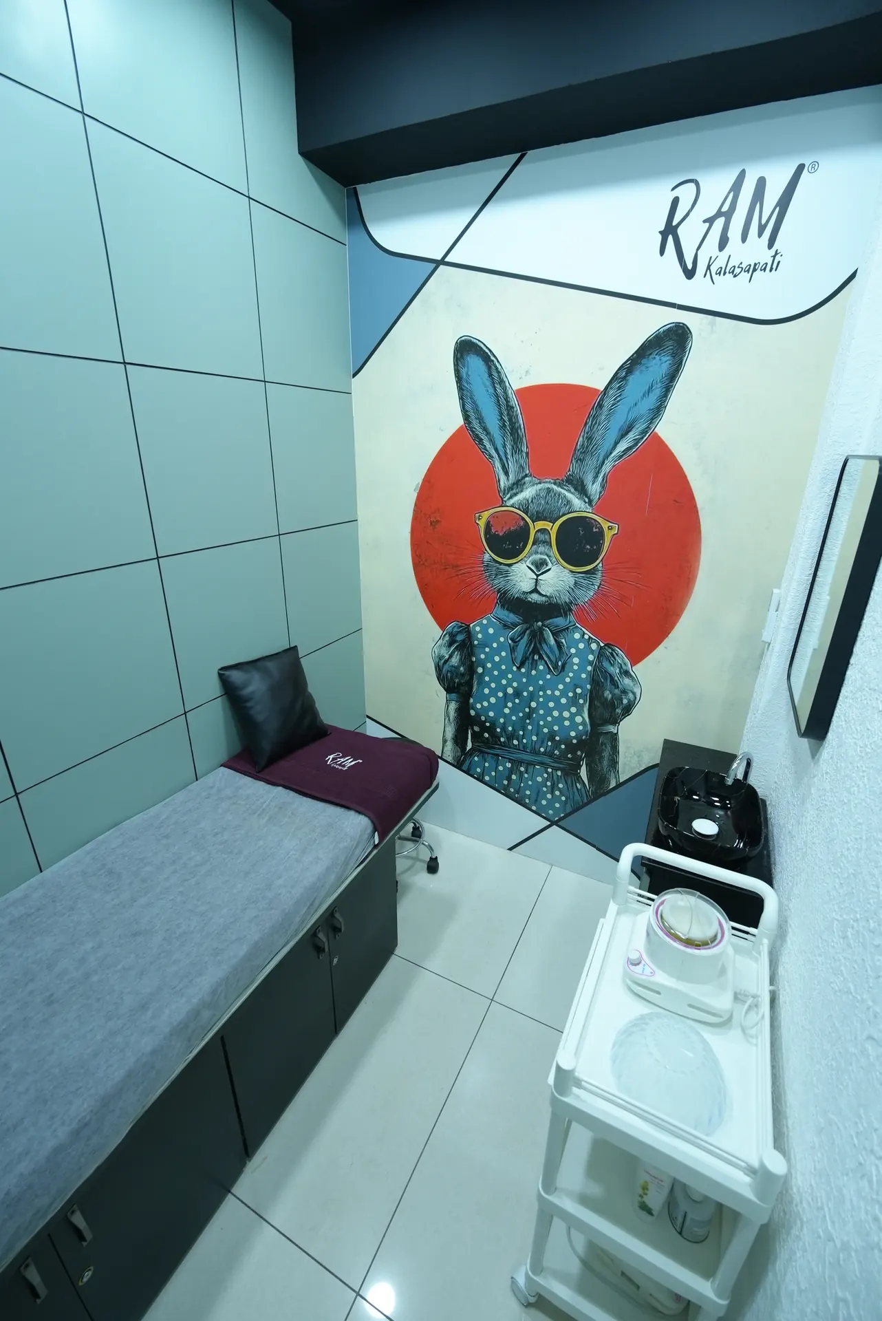 RAM KALASAPATI treatment room with service bed and wall art