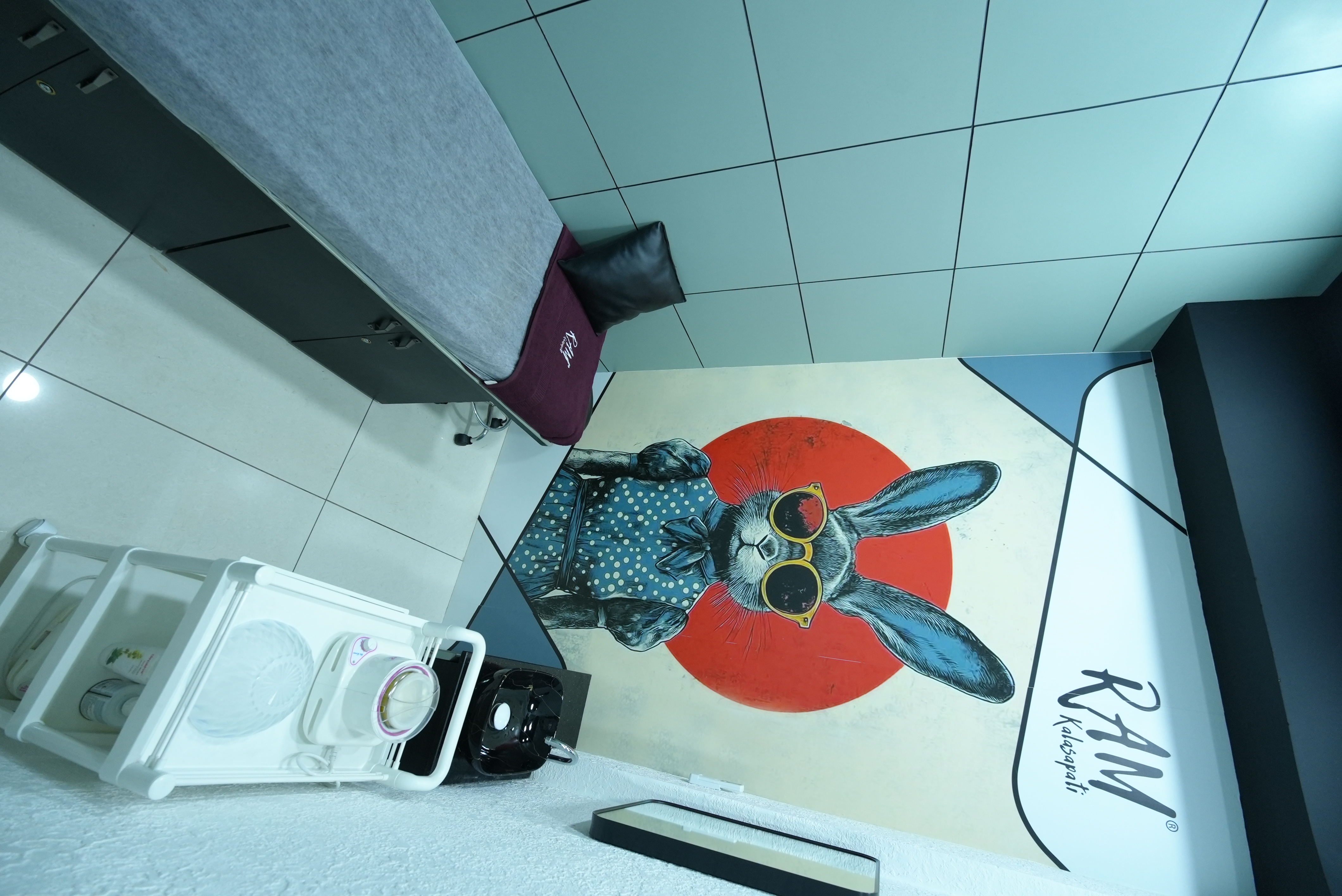 RAM KALASAPATI treatment room with service bed and wall art