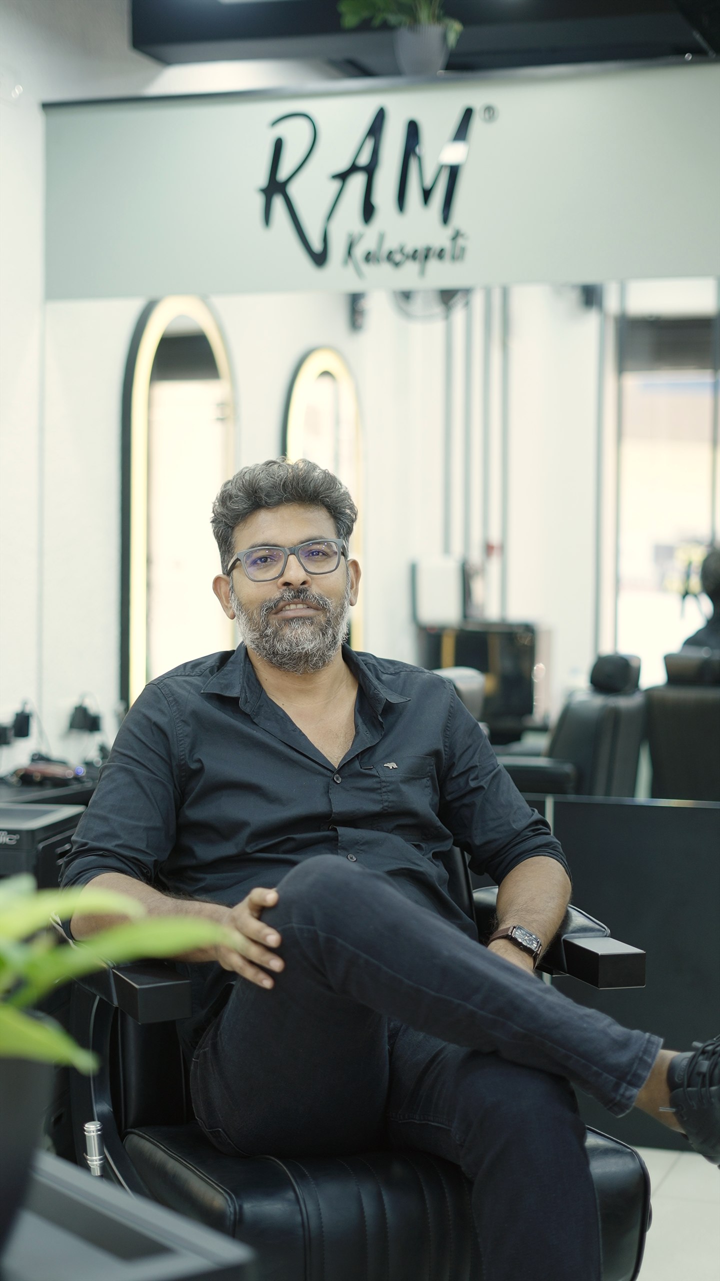 Ram Kalasapati seated in a styling chair inside the salon